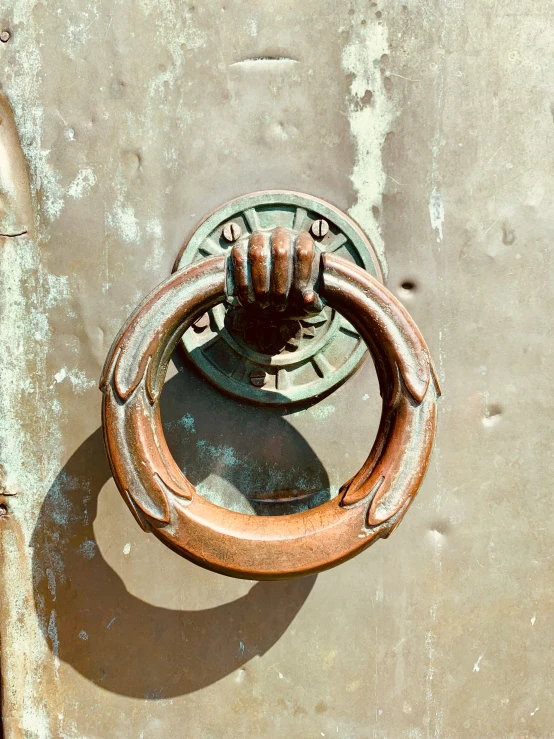 a rusted metal door knockery on the side of a building