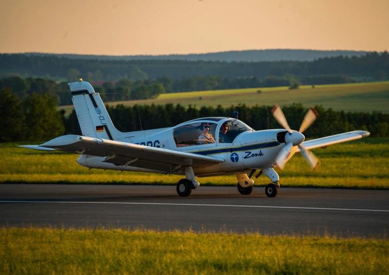 a small plane taking off on a paved road