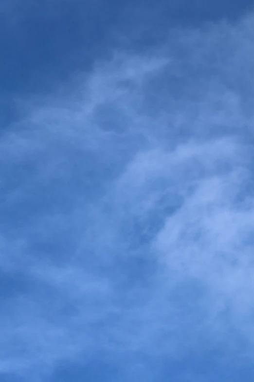 an airplane flies in the sky with white clouds