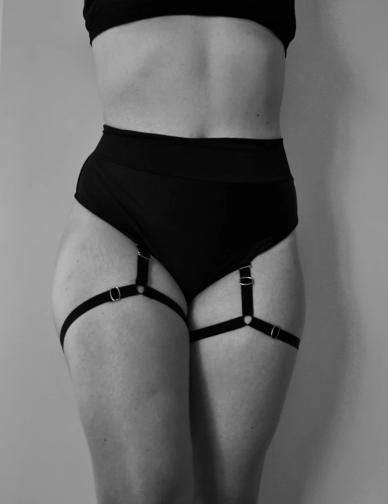 a woman wearing lingerie panties standing in front of a wall