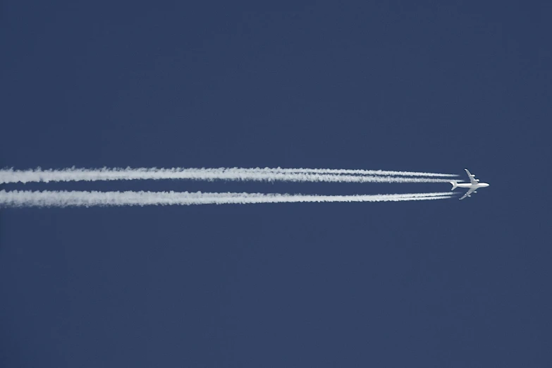 a jet airplane that is flying across a blue sky