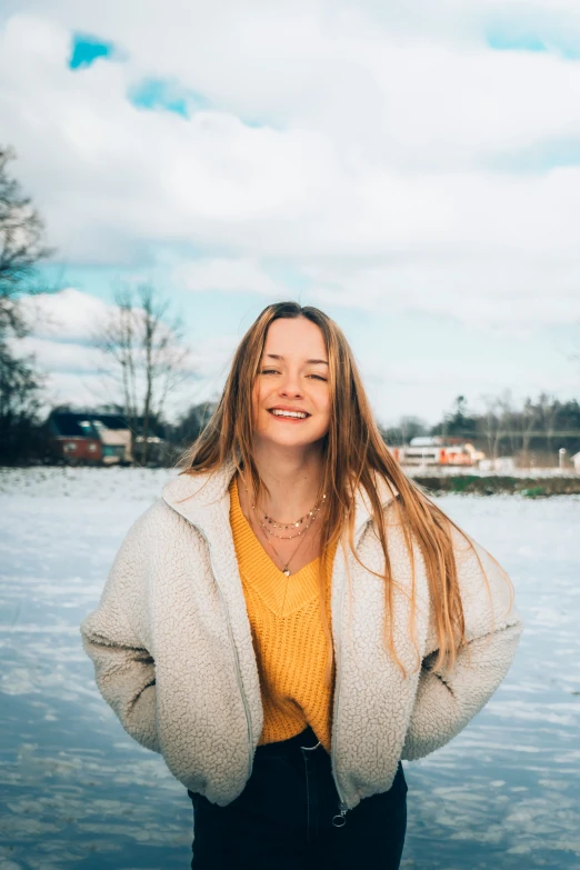 a beautiful woman standing near the water with her hands on her hips