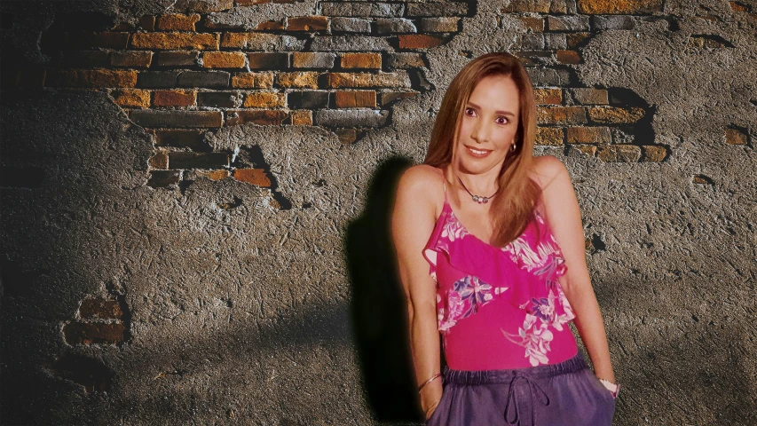 woman posing in front of a brick wall and purple pants