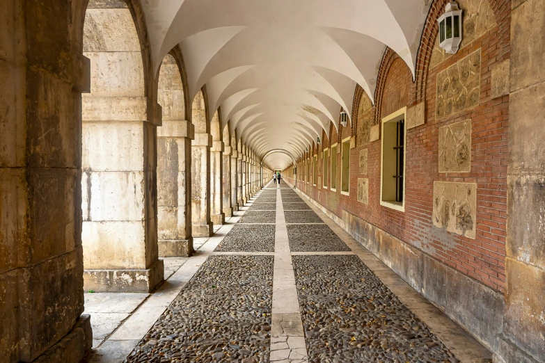 a long walkway between two brick buildings