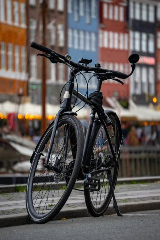 a bicycle parked next to some buildings with one leaning on the curb