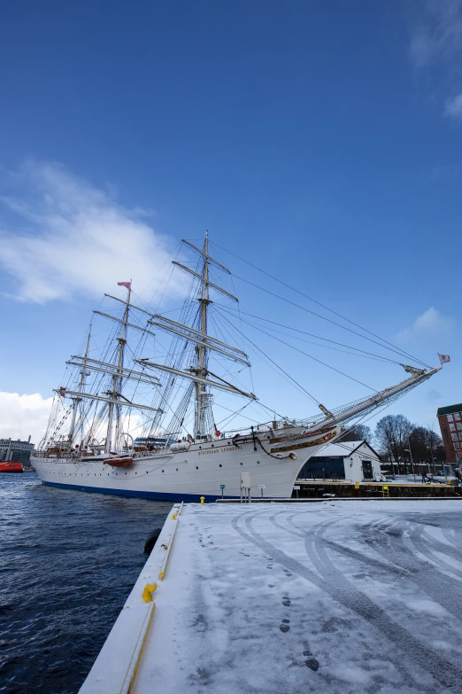 a ship docked in the harbor while covered in snow