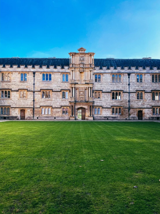 a tall stone building sitting on top of a lush green field