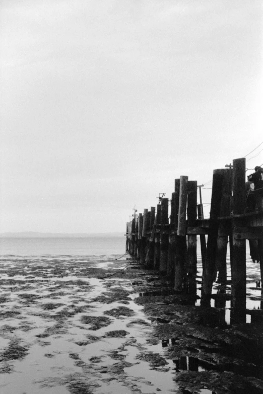 there is a large piece of wooden bridge at the beach