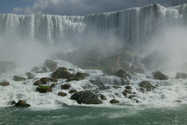 waterfall located in the foreground with fog rising into the air