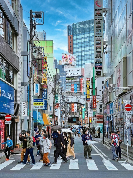 a busy city street filled with people carrying umbrellas