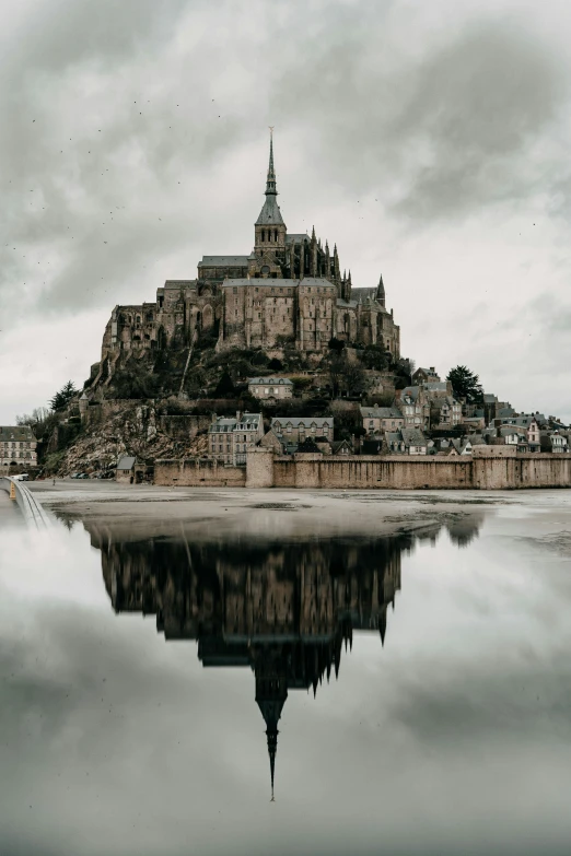 the reflection in the still water is seen of a castle