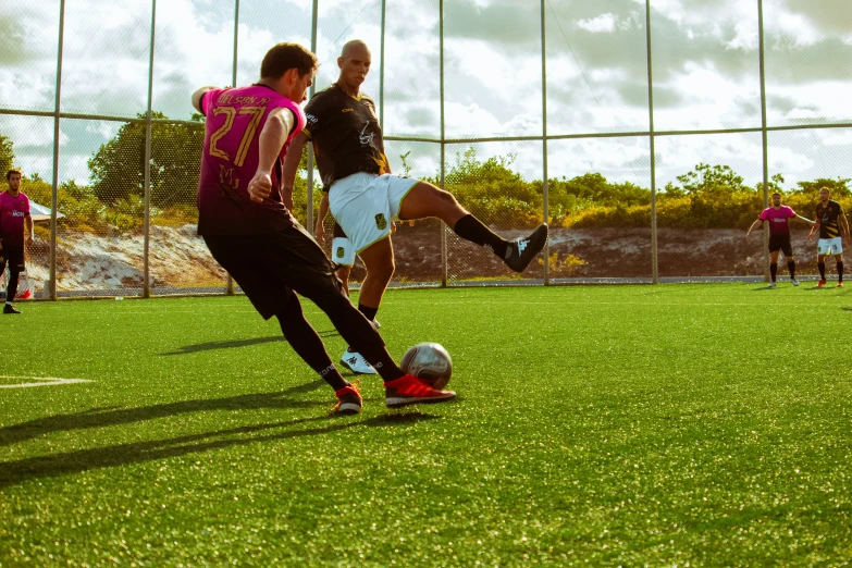 three people playing soccer on the grass outside