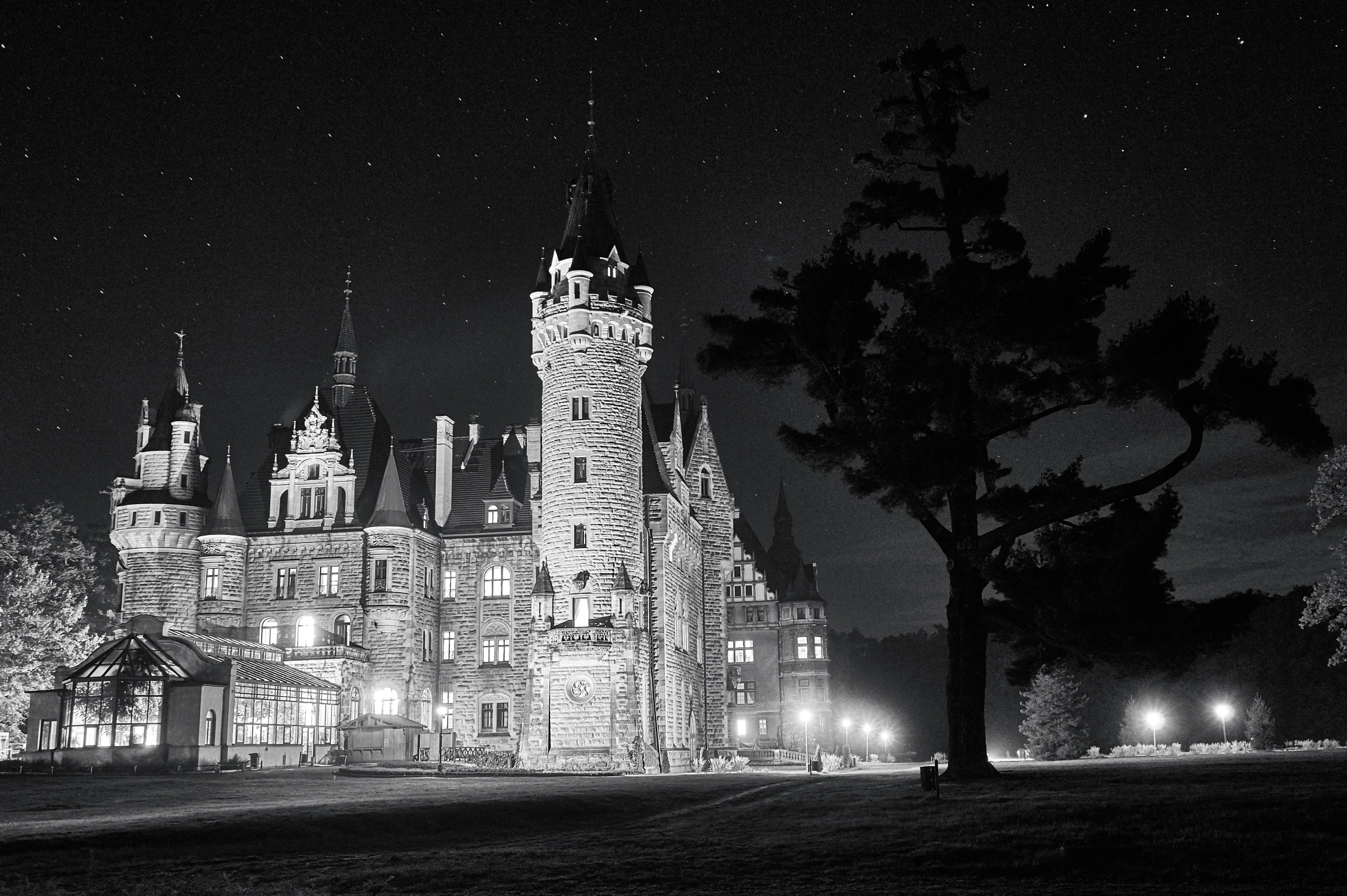 an old gothic styled house at night with its clock tower lit up