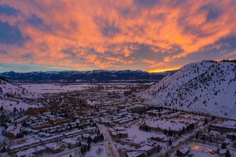 the sun is setting over a snowy landscape