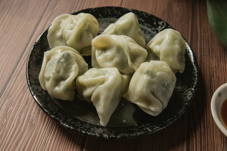 a plate with some meat dumplings sitting on a table