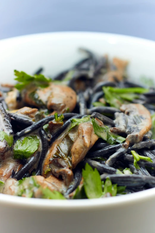 a bowl of noodles topped with mushrooms and parsley