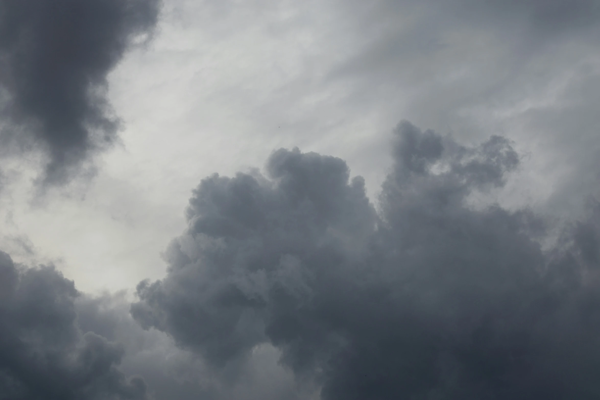 there is an airplane flying on a cloudy day