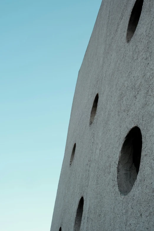 a building made out of cement with round holes