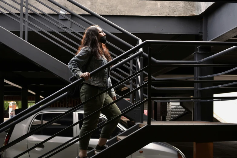 the woman is standing in front of a metal stair rail