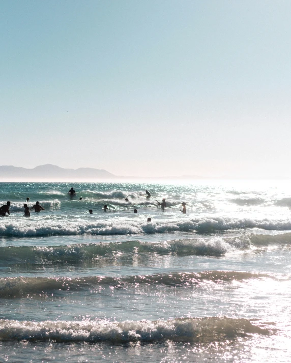 people on surfboards in the waves at the beach