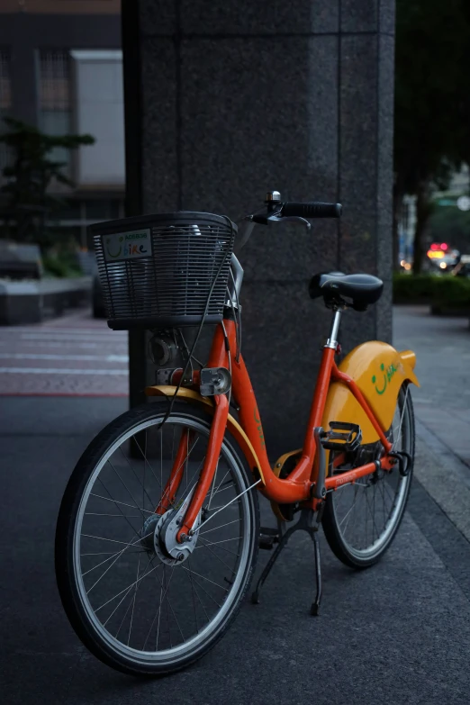 a bicycle with an orange frame sits on the street