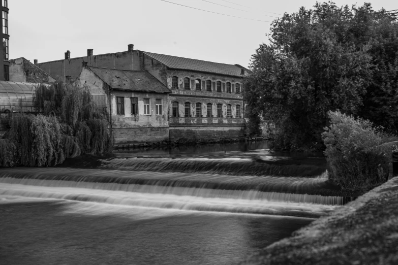 an old water mill with a bunch of trees in front of it