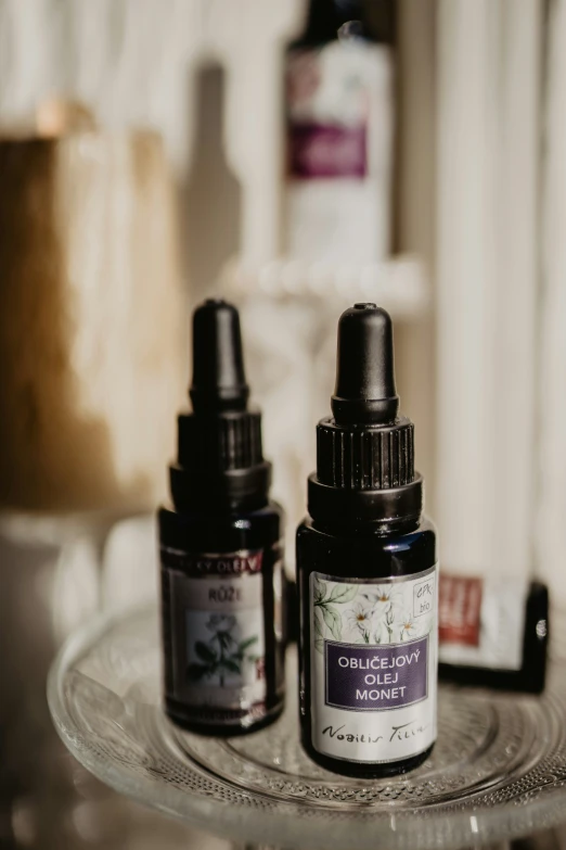 two bottles of pure essential oil on a glass table