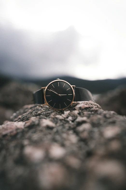 a watch lying on top of a rock