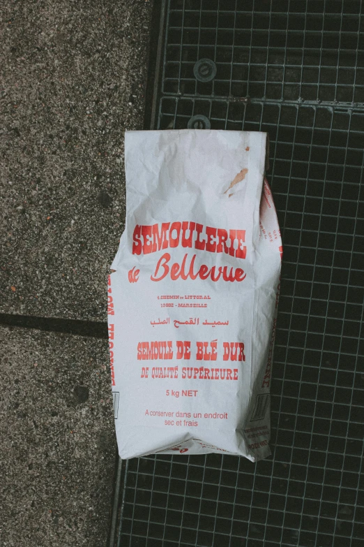 a white paper bag is placed on the ground