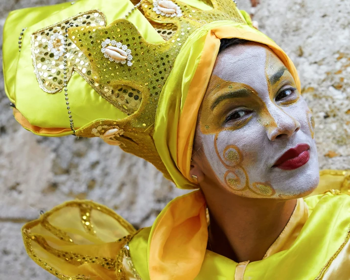 a woman wearing colorful headgear and face paint