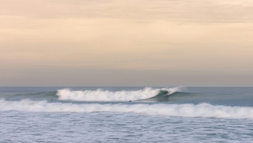 a person riding a wave on top of a surfboard