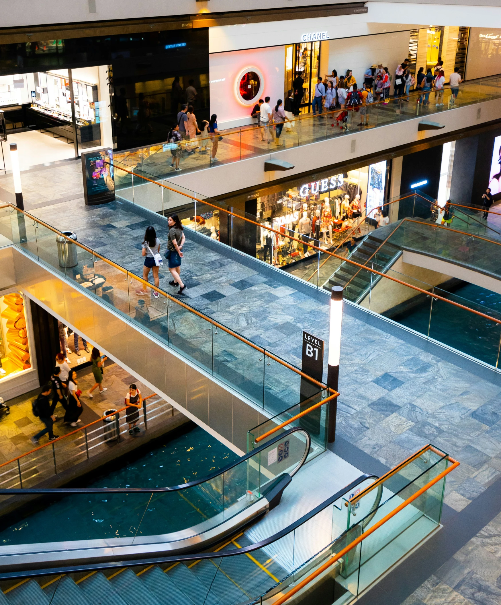 a group of people are walking up stairs inside of a store