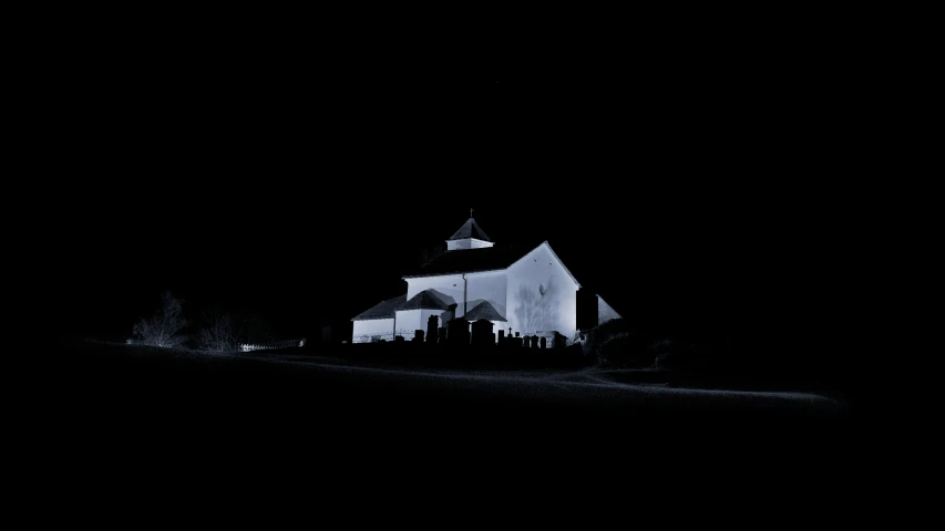 a dark picture of a barn and trees in the distance