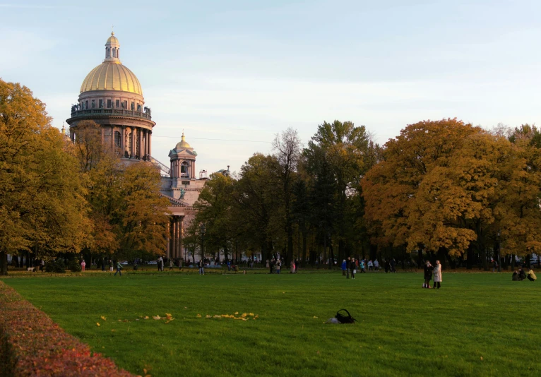 people are in the grass near a large dome building