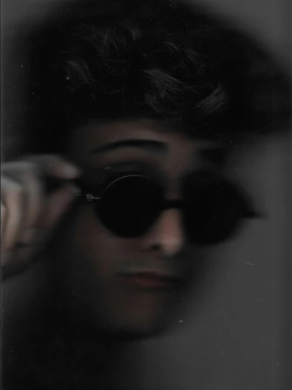 a man in black sunglasses is reflected in a mirror