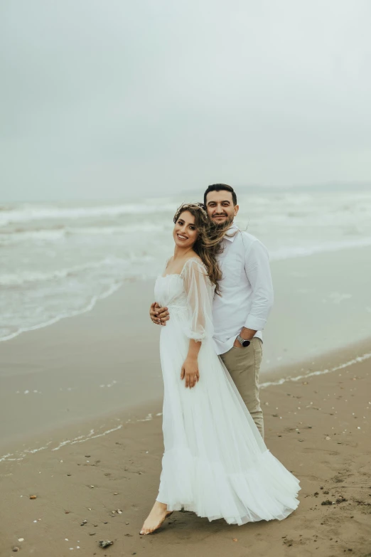 a man and a woman that are standing in the sand