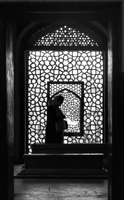 silhouette of a person looking through a screen