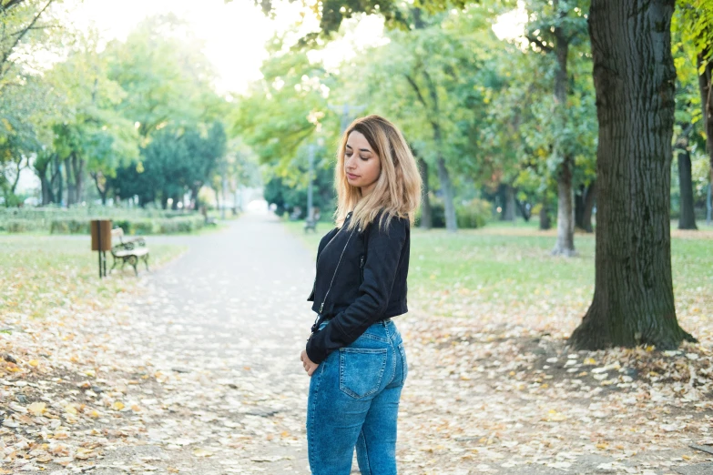 a woman standing in the park on a cloudy day