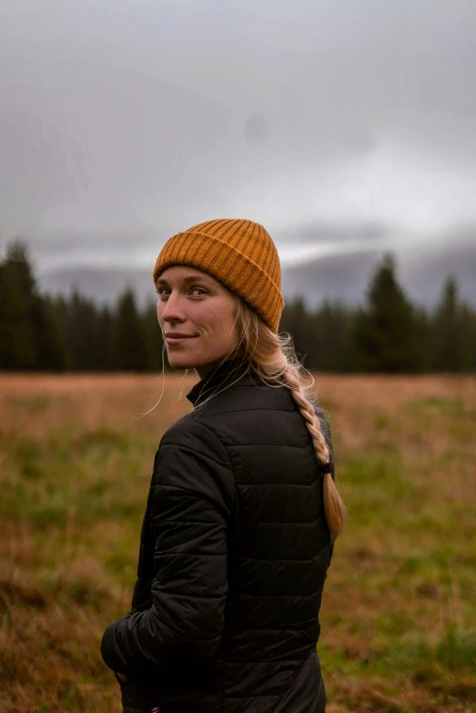 the girl stands in the field looking at the distance