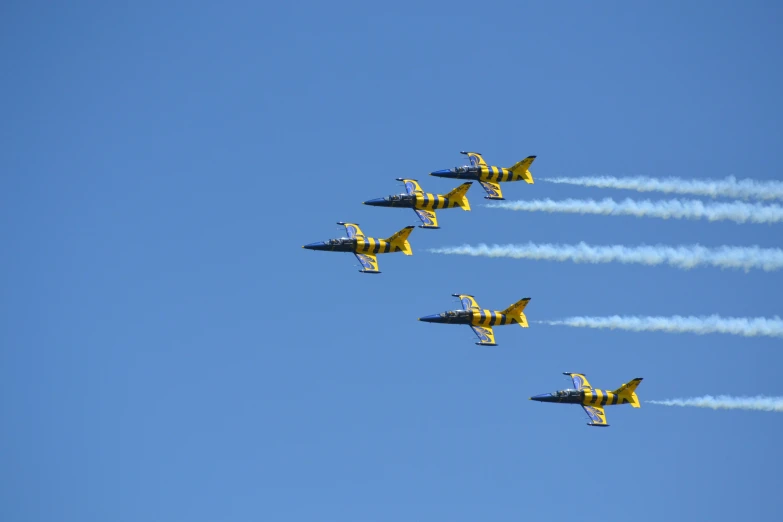 four airplanes with exhaust coming from them flying in the air