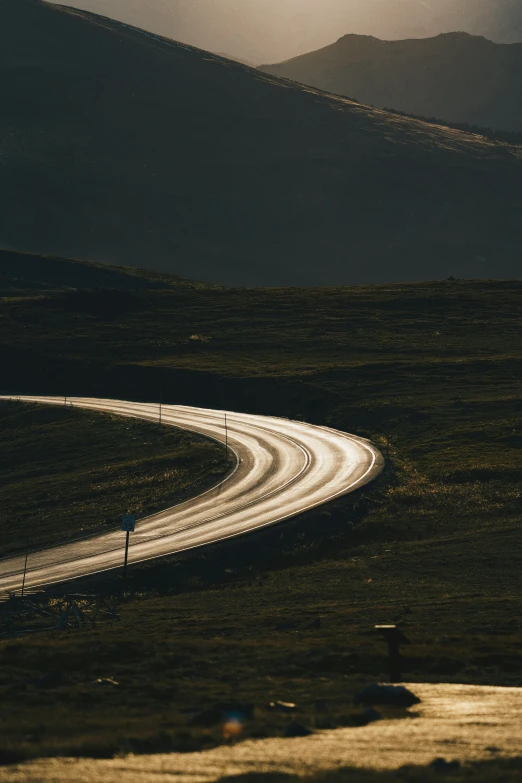 a lonely highway curves into the distance under the night sky