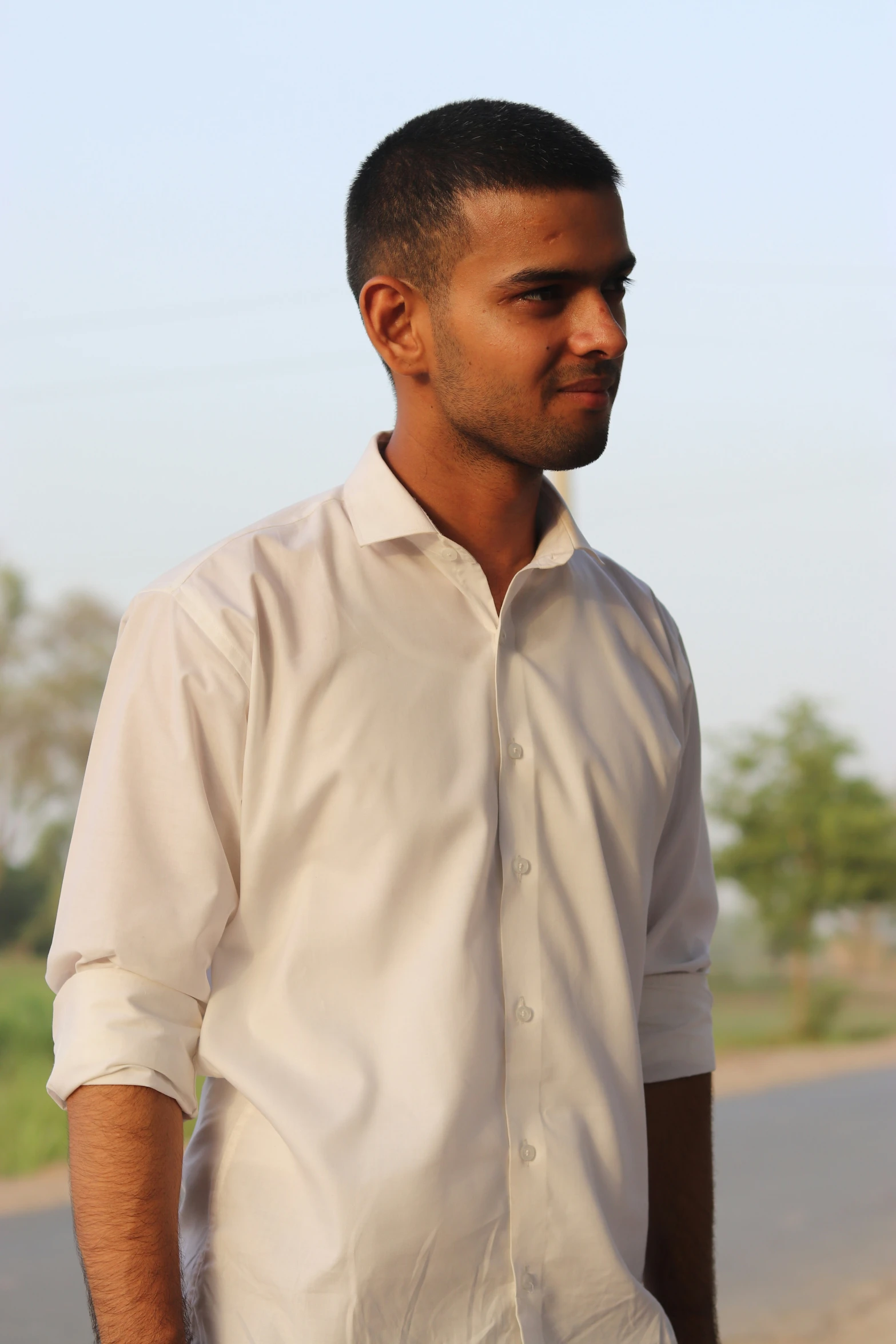 a man looks down while standing on the street