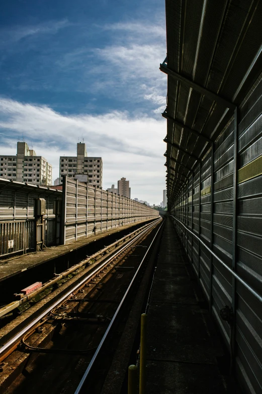 some train tracks under a blue cloudy sky