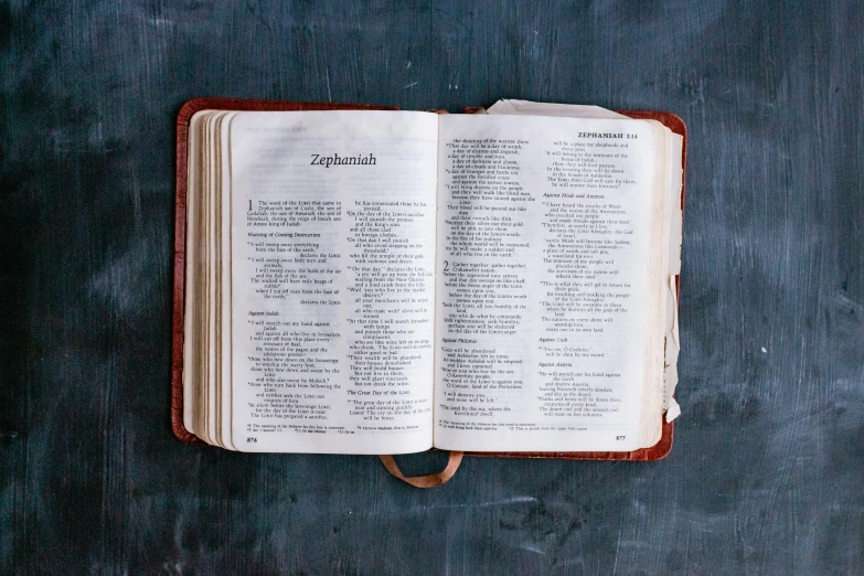 a leather bible opened on top of a blue cloth