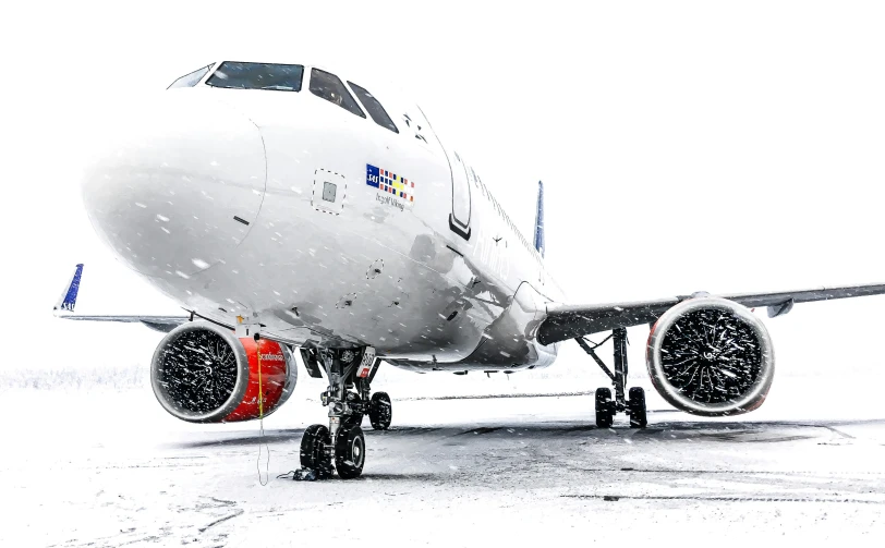 a passenger jet sits on the runway in the snow