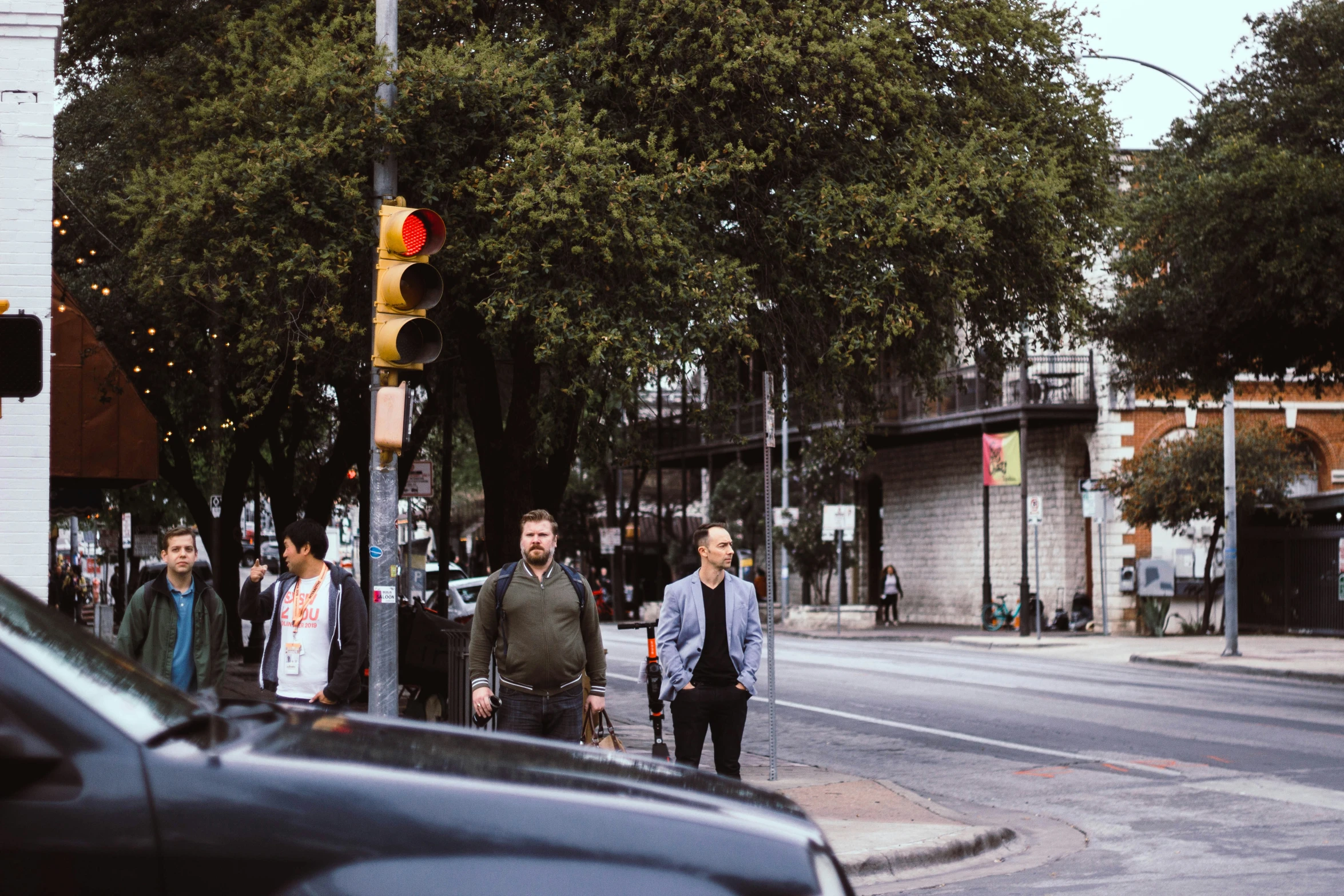 people crossing the street in the city with green traffic lights