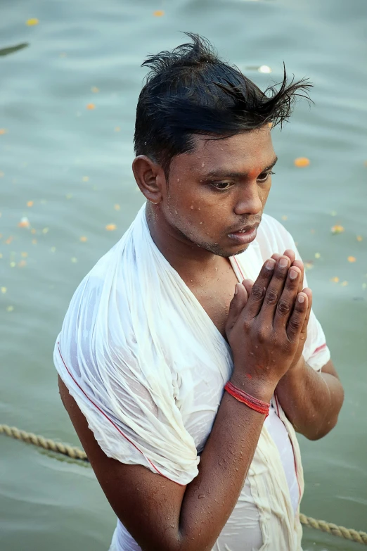 a man with his hands folded over his body