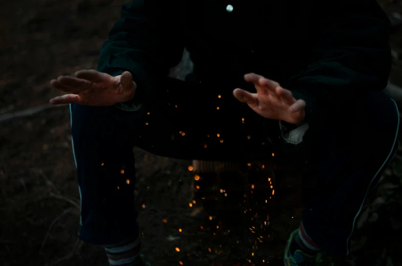 a man sitting on top of a fire filled ground