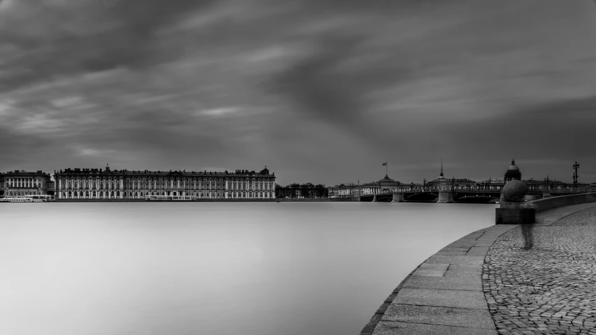 black and white pograph of large building next to water