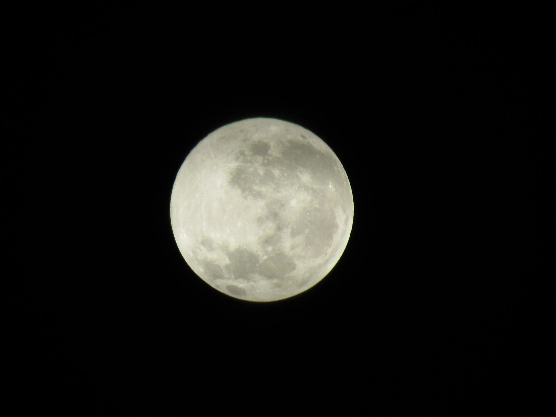 the large moon is rising over a city